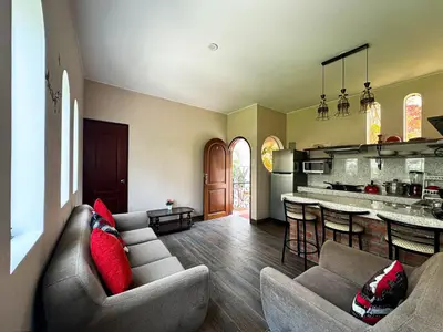 a living room with a couch and a kitchen at Casa Hotel Mamaluna in Lunahuaná