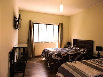 a bedroom with two beds and a window at Casa Hotel Mamaluna in Lunahuaná