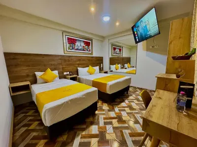 a hotel room with two beds and a flat screen tv at Cesars Hotel Lima in Lima