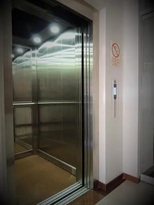 a glass elevator in a building with a no smoking sign at Cesars Hotel Lima in Lima