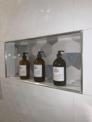 three bottles of soap on a shelf in a bathroom at Cesars Hotel Lima in Lima