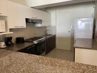 a kitchen with white cabinets and a stove and a refrigerator at Book in Miraflores - Lima in Lima