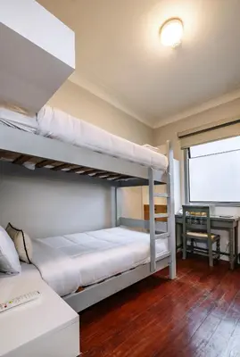 a bedroom with two bunk beds and a desk at TARATA BOUTIQUE HOTEL in Lima