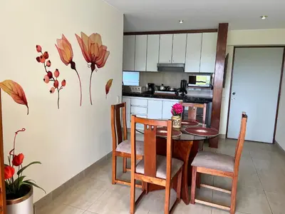 a kitchen with a table and chairs in a room at Bonito depa san isidro cama queen home office wifi y cochera in Lima