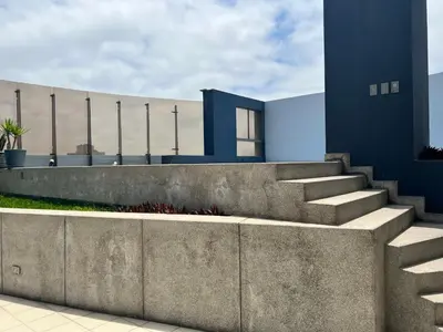 a concrete retaining wall with stairs in front of a building at Bonito depa san isidro cama queen home office wifi y cochera in Lima