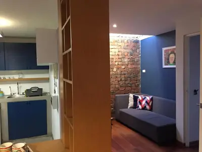 a living room with a couch and a kitchen at Departamento Cool & Comodo, San Isidro in Lima