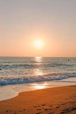 a beach with the sun setting over the ocean at VIVEMAR PUNTA HERMOSA - Beach House Lima - Perú in Punta Hermosa