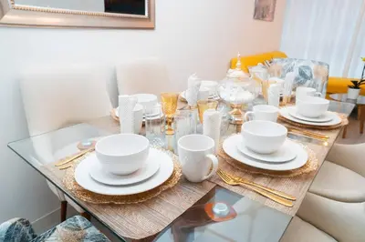 a glass table with plates and cups on it at Hermoso departamento de 3 habitaciones in Lima