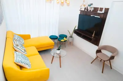 a living room with a yellow couch and a tv at Hermoso departamento de 3 habitaciones in Lima
