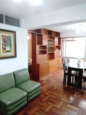 a living room with a green couch and a table at BONITO DEPARTAMENTO EN MIRAFLORES in Lima