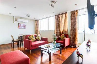 a living room with red furniture and a table at Apartamentos Estela en Alameda colonial - 5km Aeropuerto Jorge Chávez in Lima