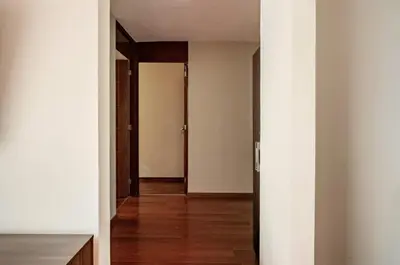 an empty hallway with white walls and wooden floors at Apartamentos Estela en Alameda colonial - 5km Aeropuerto Jorge Chávez in Lima