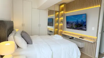 a bedroom with a white bed and a tv on a wall at APARTAMENTO KELVIN - Edificio ON APARTMENTS in Lima