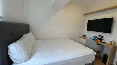 a small bedroom with a white bed and a television at APARTAMENTO KELVIN - Edificio ON APARTMENTS in Lima
