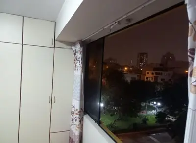 a window with a view of a city at night at Frente a hermoso Parque Pueblo Libre in Lima
