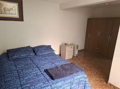 a bedroom with a bed with blue sheets and a cabinet at Amplio Departamento Residencial en La Molina in Lima