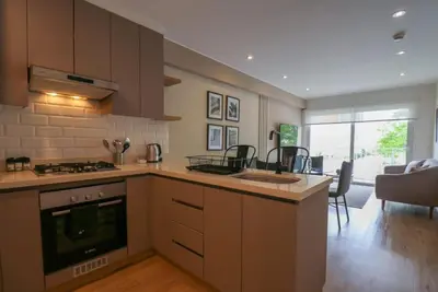 a kitchen with a stove top oven next to a living room at Morada by Wynwood House in Lima