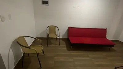 a red couch and two chairs in a room at Departamentos Alcanfores 775 Miraflores in Lima