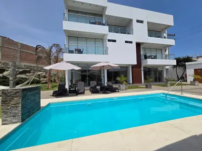 a swimming pool in front of a building at Silver Inn Hotel in Cerro Azul