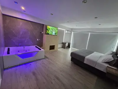 a bedroom with a bed and a tub with purple lights at Silver Inn Hotel in Cerro Azul