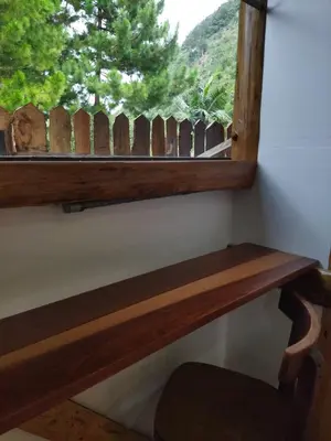a window with a wooden bench and a fence at Fachwerkhaus zum Hirsch in Oxapampa