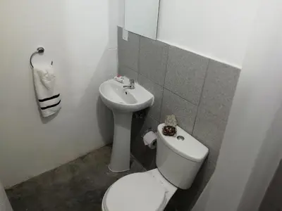a white bathroom with a toilet and a sink at Pacific Spot San Miguel in Lima