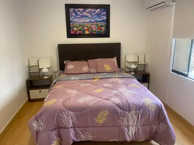a bedroom with a bed with a purple comforter at 23 Dpto de Estreno Miraflores in Lima