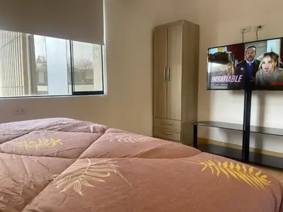 a bedroom with a bed and a flat screen tv at 23 Dpto de Estreno Miraflores in Lima