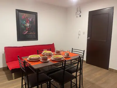 a dining room table with chairs and a red couch at 23 Dpto de Estreno Miraflores in Lima