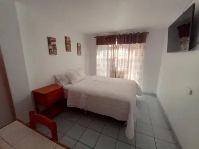 a bedroom with a white bed and a window at Hotel MESONERO in Ayacucho
