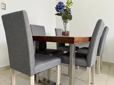 a dining room table with four chairs and a vase of flowers at MH Apartments Ica 2 in Ica