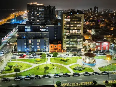 a city at night with cars parked in a parking lot at San Miguel Exclusivo Depa Vista al Mar, piscina in Lima