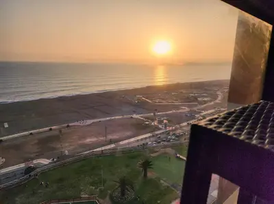 a view of the ocean at sunset from a building at San Miguel Exclusivo Depa Vista al Mar, piscina in Lima