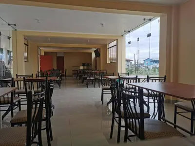 a dining room with tables and chairs and windows at Catalina Huanca Resort in San Jerónimo