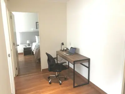 a desk with a laptop and a chair in a room at Hermoso apartamento con piscina Miraflores- Canvas in Lima