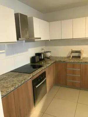 a kitchen with white cabinets and a stove top oven at Hermoso apartamento con piscina Miraflores- Canvas in Lima