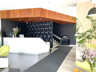 a lobby with a white table and yellow chairs at Hermoso apartamento con piscina Miraflores- Canvas in Lima