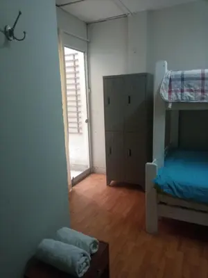 a room with a bunk bed and a bedroom with a door at Mochileros in Lima