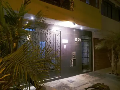 a front door of a building with a plant at Mochileros in Lima