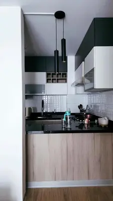 a kitchen with a black counter top and wooden cabinets at Depa acogedor en el corazón de la ciudad in Lima