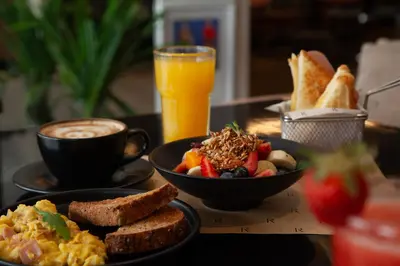 a table with two plates of breakfast foods and a cup of coffee at ARTE HOTEL Lima in Lima