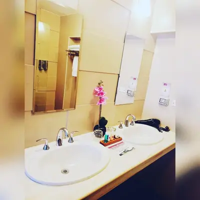 a bathroom with two sinks and a mirror at Hotel Andesmar in Lima