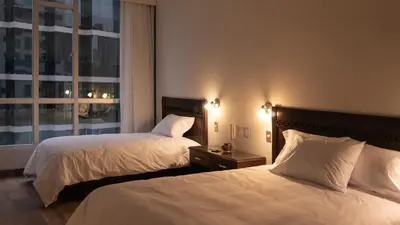 a hotel room with two beds and a window at LIMA HOST in Lima