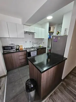 a kitchen with a counter and a refrigerator at Dpto acogedor con terraza privada in Lima