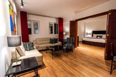 a living room with a couch and a bed at El Polo Hotel & Suites in Lima