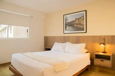 a bedroom with a white bed and a picture on the wall at Cantuarias 355 by Wynwood House in Lima
