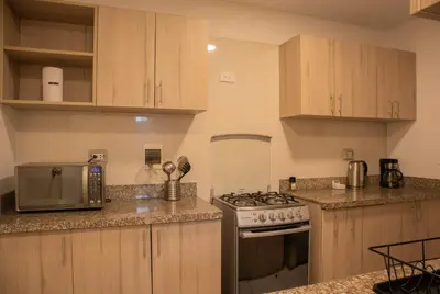 a kitchen with wooden cabinets and a stove top oven at Cantuarias 355 by Wynwood House in Lima
