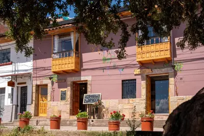 a pink building with wooden balconies on a street at Casa Antade Cusco in Cusco