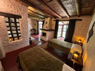 a large room with two beds and a fireplace at Darenas Hacienda in Aucallama