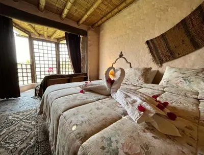 a bedroom with two beds in a room with windows at Darenas Hacienda in Aucallama
